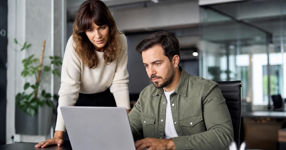 Two office professionals calmly confirming an agreed decision and next step together immediately after a discussion.
